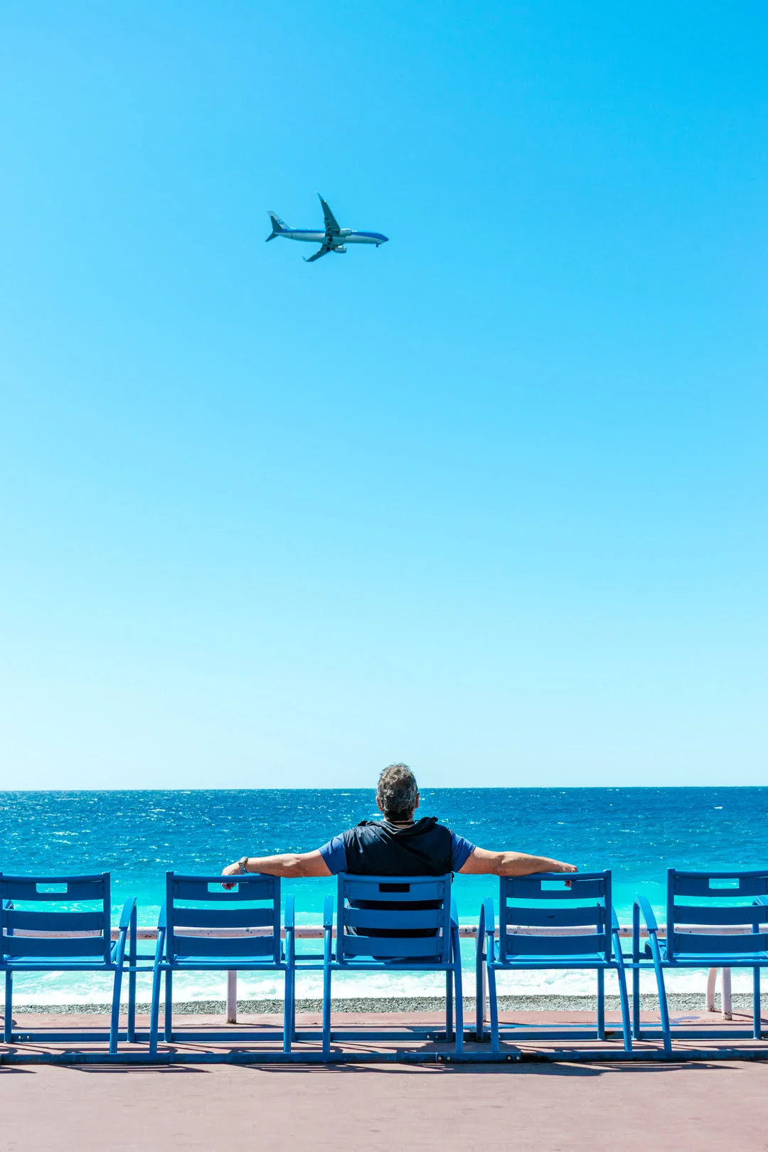 Portrait d’un homme de dos assis sur une chaise bleu réalisé à Nice, photographié par un photographe professionnel spécialisé dans la photo de portrait à Fréjus.
