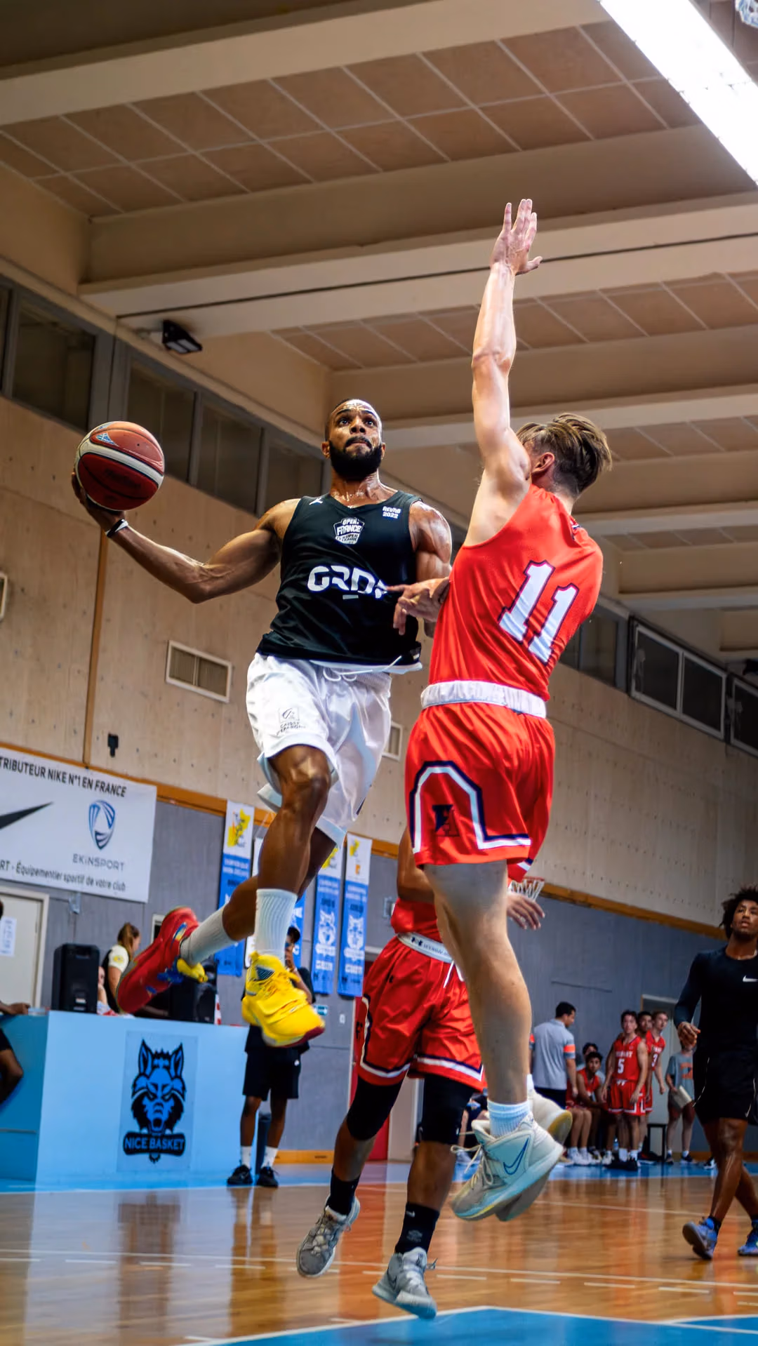 Photographe de sport capturant un joueur de basketball en plein saut lors d’un match à Fréjus.