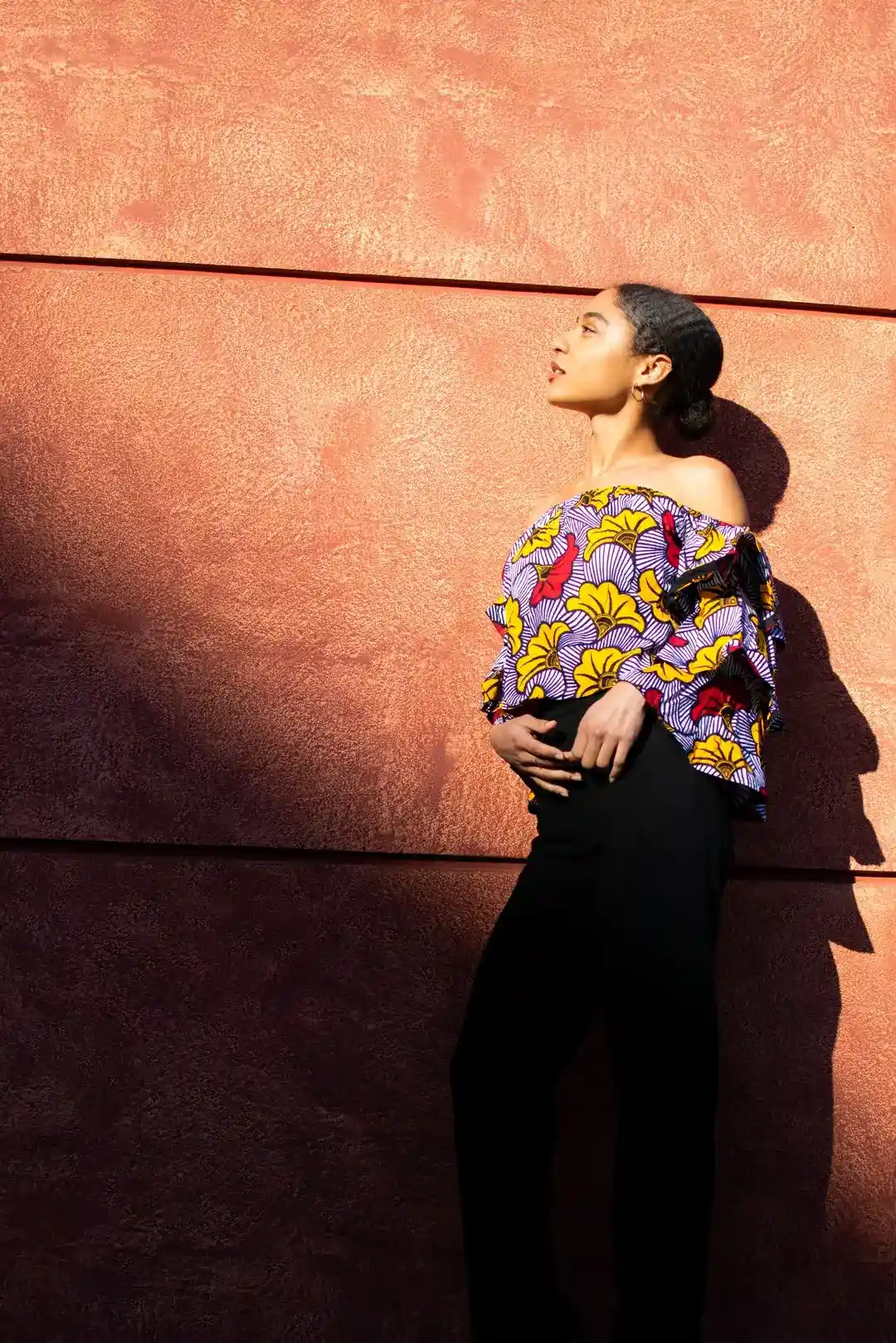 portrait d'une femme contre un mur sous un coucher soleil à fréjus